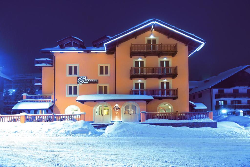 a large building in the snow at night at Hotel Bes & Spa in Claviere