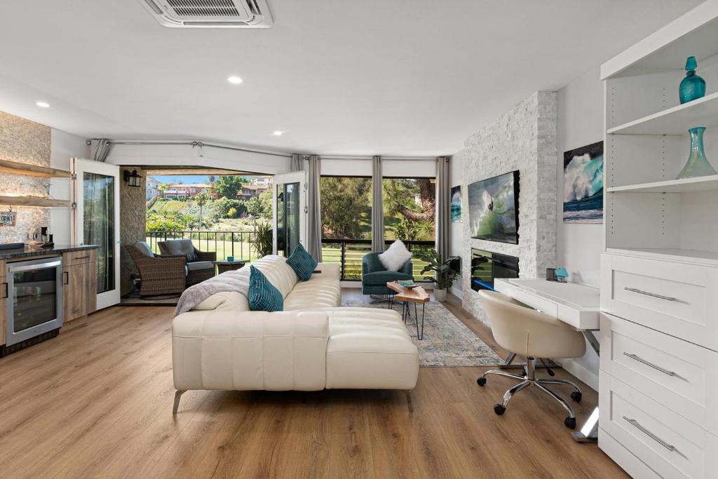 a living room with a white couch and a desk at Fairway Haven - CB2507 in Carlsbad