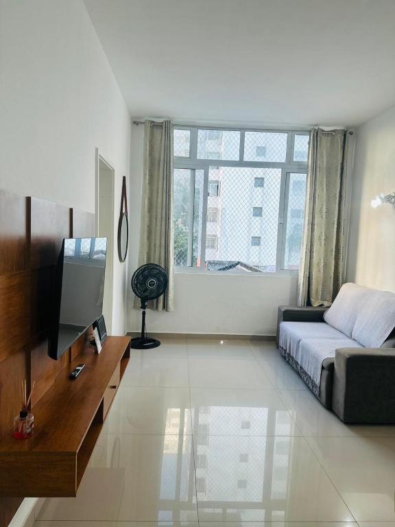 une chambre avec un lit et une télévision dans l'établissement Apartamento em Guarujá Centro, à Guarujá