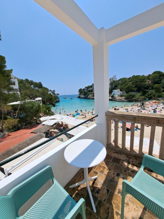 a balcony with chairs and a view of the beach at Hostal Playa in Cala Santanyi