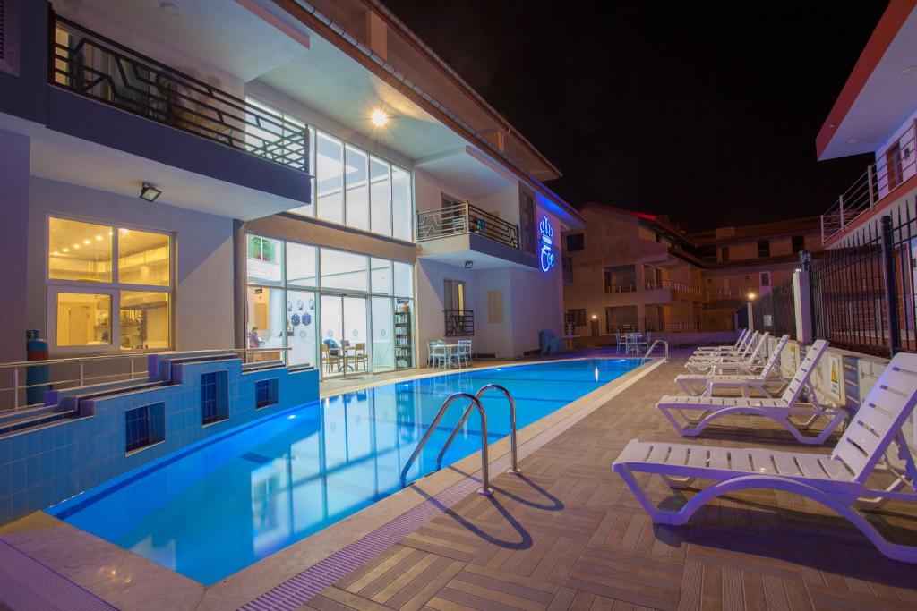 a pool in a hotel with lounge chairs next to it at Pamukkale Termal Ece Otel in Pamukkale