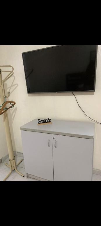 a flat screen tv on top of a white cabinet at Pousada da vila in Abelardo Luz