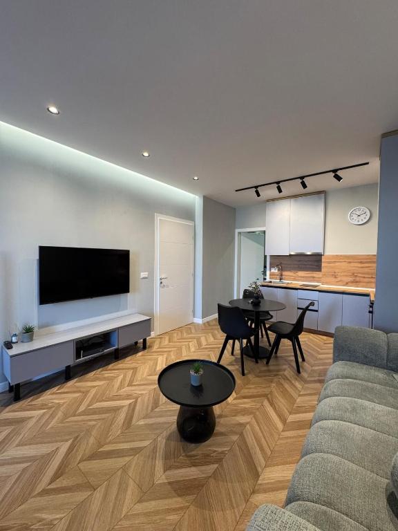 a living room with a couch and tables and a television at The Best Shkoder in Shkodër