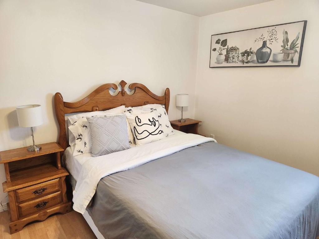a bedroom with a bed with white sheets and pillows at Logis des prodiges - Le 775 in Rouyn-Noranda