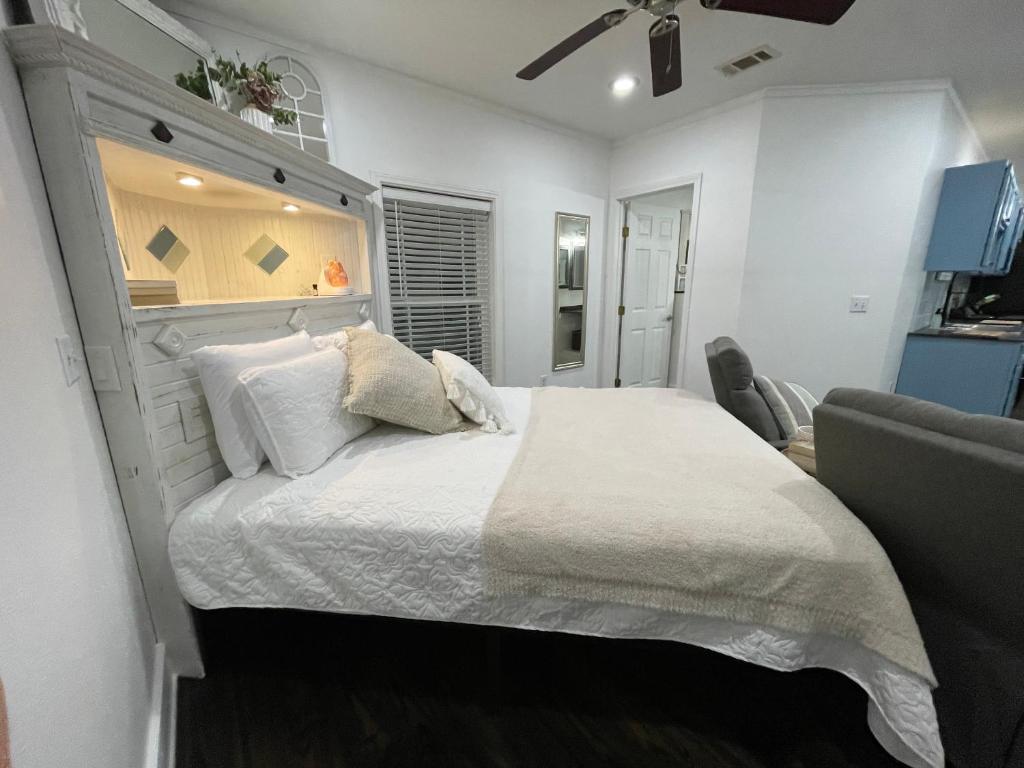 a bedroom with a large white bed and a couch at West Sunset Studio in Atmore