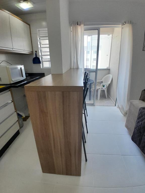 a kitchen with a counter and chairs in a room at Apartamento, 5 minutos da praia in Porto Belo