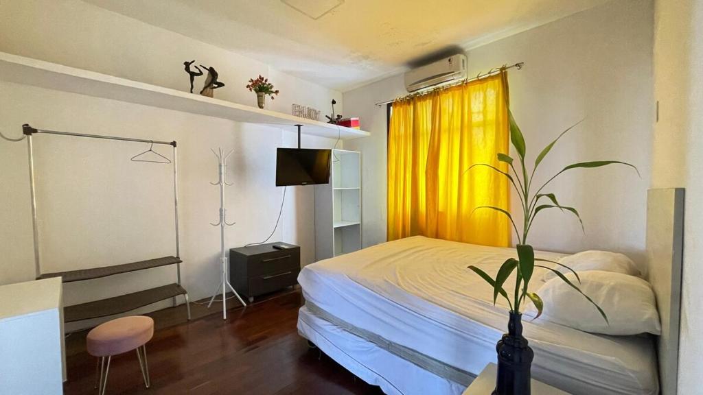 a bedroom with a bed and a yellow curtain at Apartamento na Belém Batista Campos - Com Garagem! in Belém