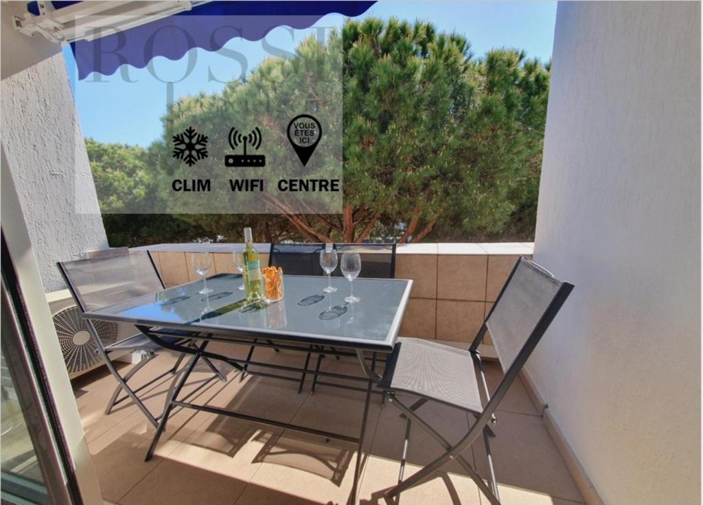 d'une table en verre et de deux chaises sur un balcon. dans l'établissement T2 cœur de ville moderne CLIM WIFI Terrasse - ROSSIconciergerie - Linge en option, à La Grande Motte