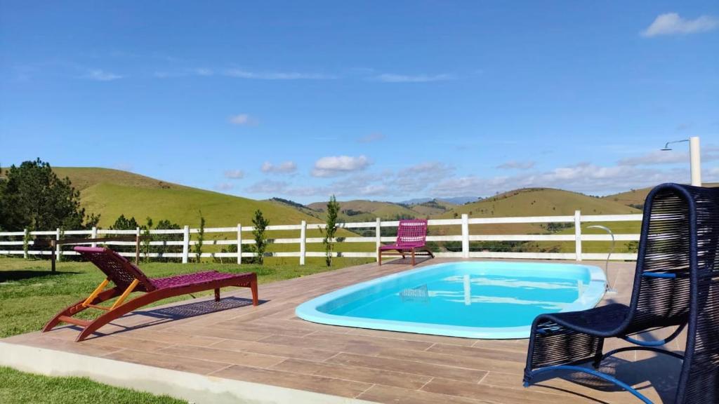 a patio with two chairs and a swimming pool at Sítio da Pedra in Cunha