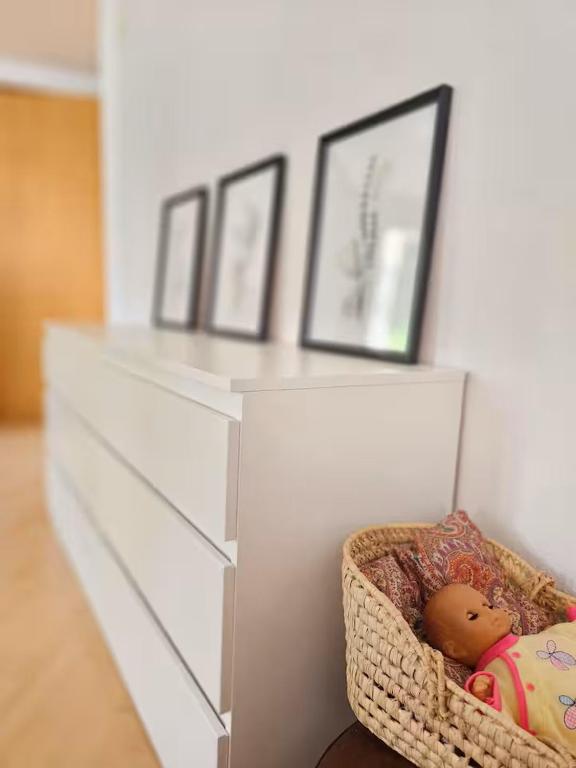 a white dresser with a doll in a basket at Perle am Vierwaldstättersee in Fluelen