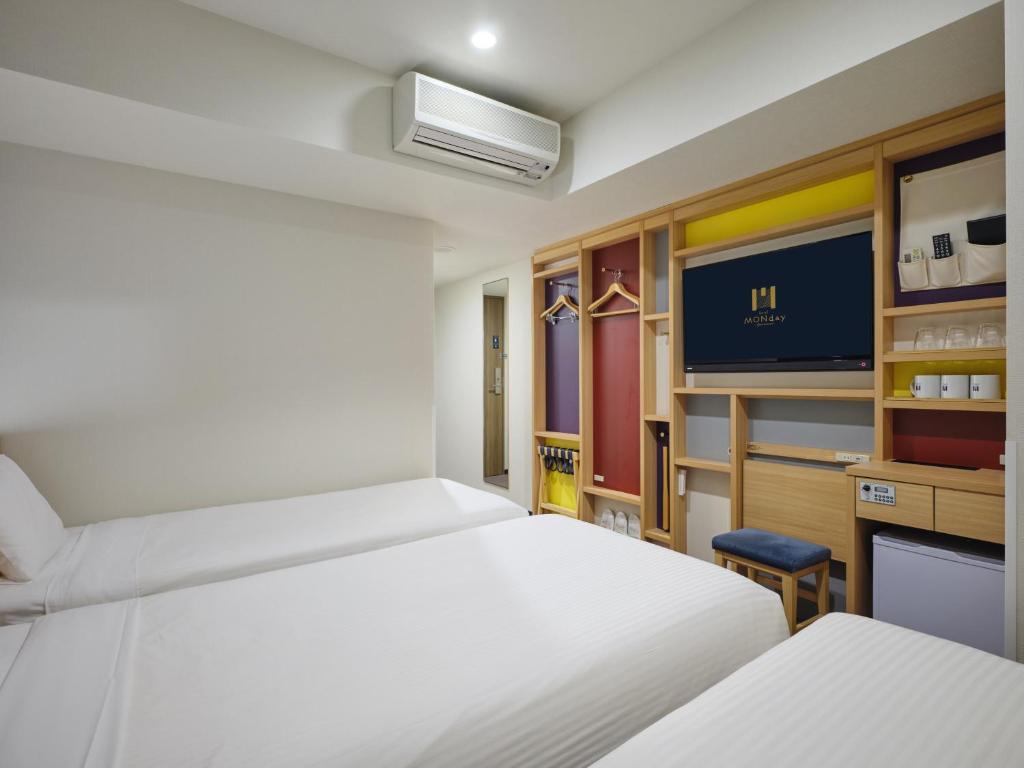 ein Schlafzimmer mit zwei Betten und einem Flachbildfernseher in der Unterkunft hotel MONday Tokyo Nishikasai in Tokio