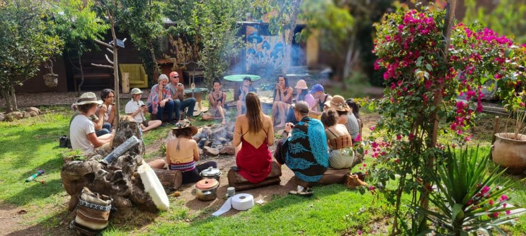 a group of people sitting on the grass in a park at Kamanti Hostel in Pisac