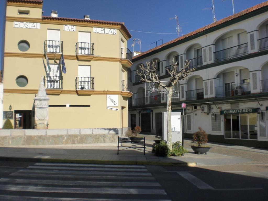 um banco sentado em frente a um edifício em Hostal DP El Pilar em Monesterio