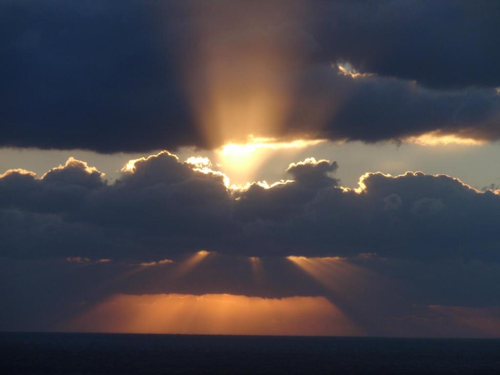 a stormy sky with the sun poking through the clouds at Traditional Studio in Kalymnos