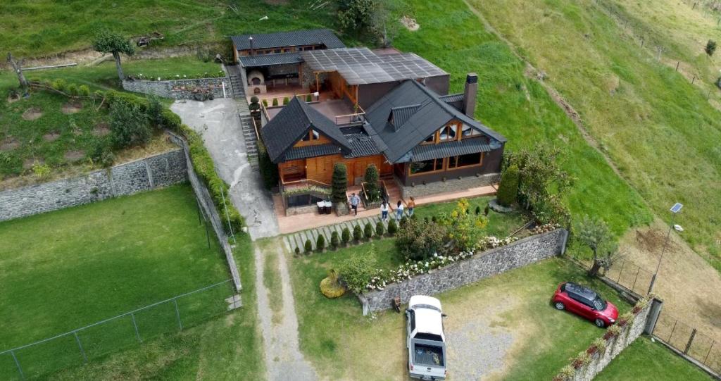 an aerial view of a large house with a van parked in the yard at Vacaciones en Cuenca, quédate en Picota Cucho una encantadora quinta VIP con jacuzzi, turco, zona BBQ a 10km del centro de la ciudad - 20 huéspedes - 3 habitaciones in Cuenca
