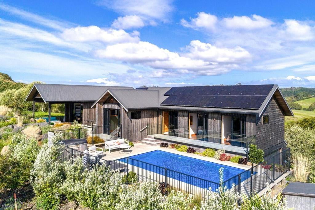 una casa con una piscina di fronte di Villa Obsidian including Obsidian Yurts by Waiheke Pure a Waiheke Island