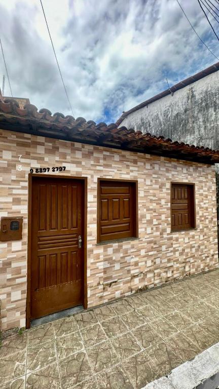a house with two garage doors and a brick wall at Casa em Itacaré no Centro, ao lado da Pituba in Itacaré