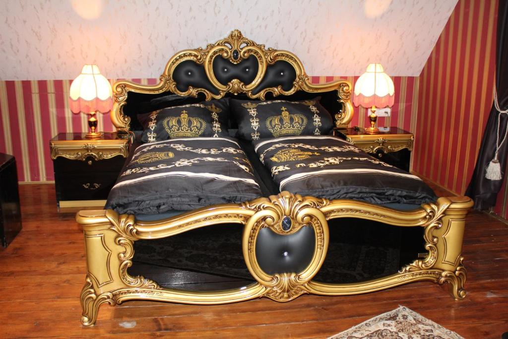 a gold and black bed with black and gold pillows at Gästehaus Mama in Rust