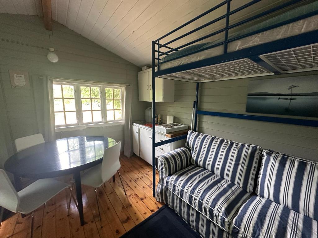 a living room with a couch and a table and a bunk bed at Turifoss Camping Cabin 2 in Svedjan
