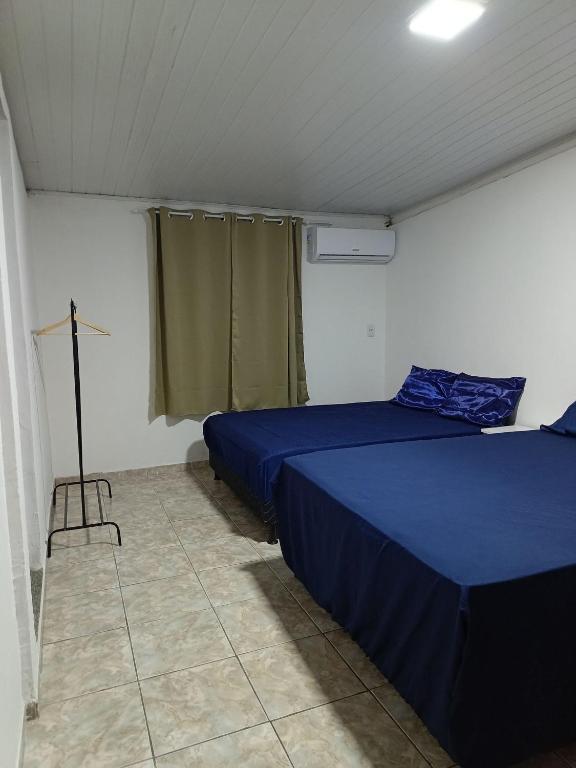 a bedroom with two beds and a cross on the floor at Temporada Peterle | Casa vista mar Irirí in Anchieta