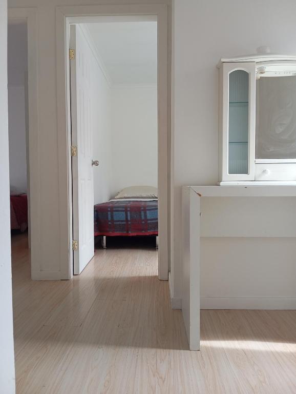 a room with a bed and a white door with a window at Camila in Punta Arenas