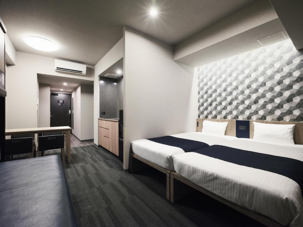 a hotel room with two beds and a desk at MONday Apart Asakusabashi Akihabara in Tokyo