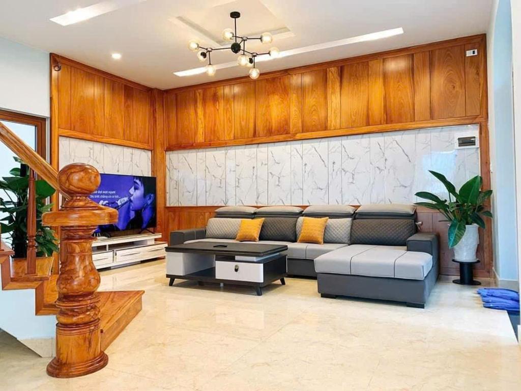 ein Wohnzimmer mit Couch und Fernseher in der Unterkunft NHỚ House IV in Da Lat