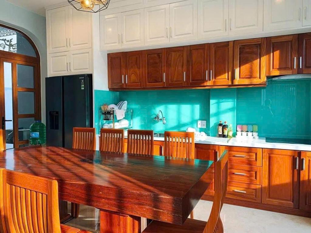 eine Küche mit einem Holztisch und Holzschränken in der Unterkunft NHỚ House IV in Da Lat