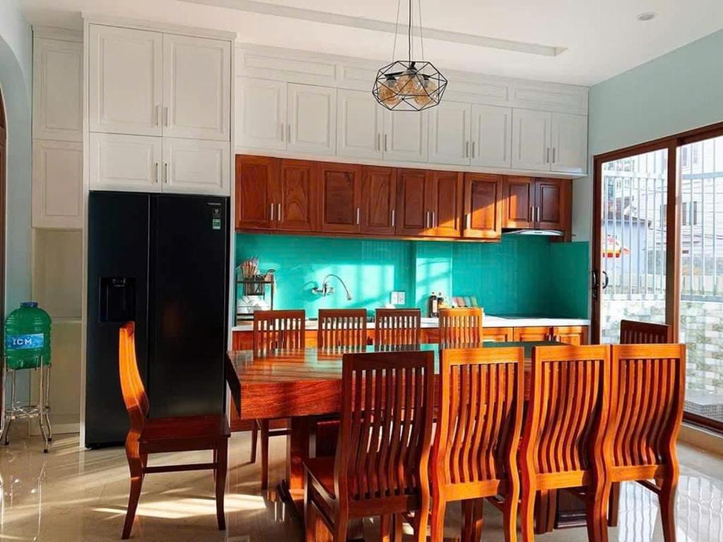 eine Küche mit einem großen Holztisch und Stühlen in der Unterkunft NHỚ House IV in Da Lat