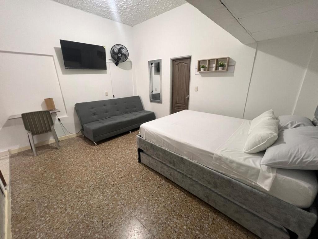 a bedroom with a bed and a couch at Acogedor apartamento en Armenia in Armenia