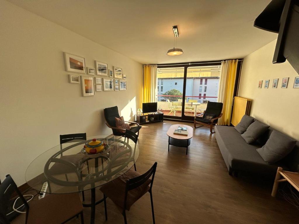 un salon avec un canapé et une table en verre dans l'établissement Duplex T3 lumineux avec terrasse, parking, à 5 min du centre - FR-1-239-1092, à Saint-Jean-de-Luz