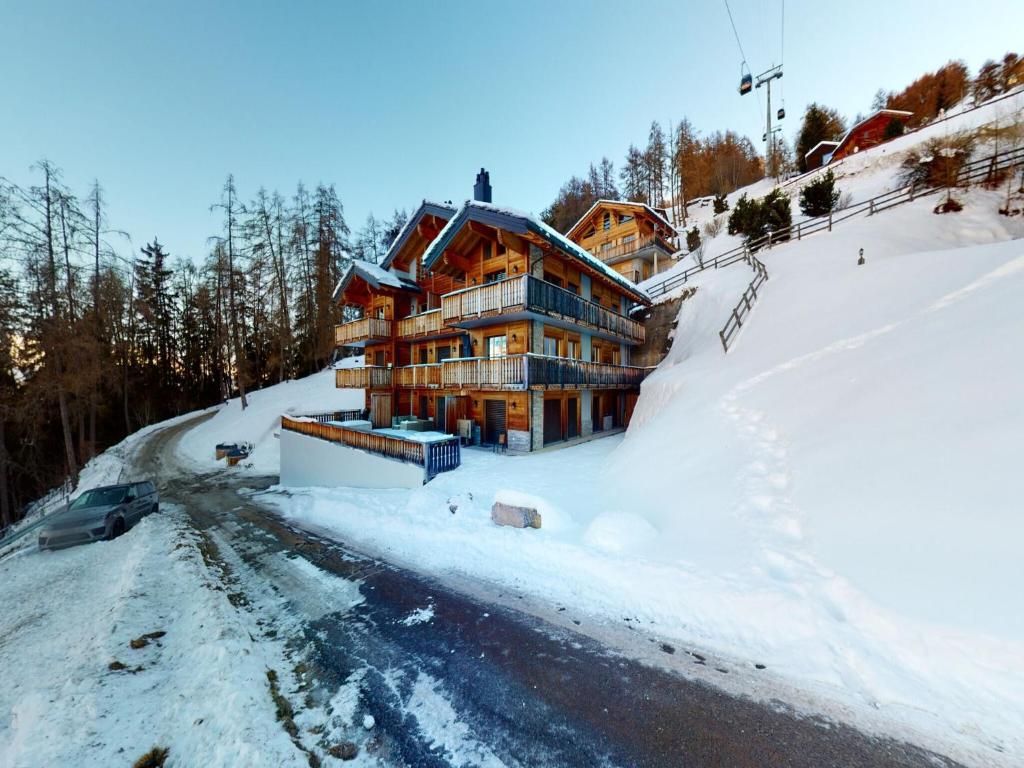 a house on a snow covered hill with a road at Apartment in Veysonnaz with Ski-In Ski-Out in Veysonnaz