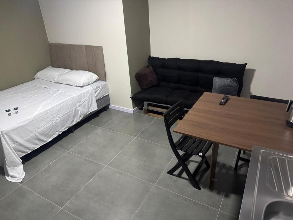 帕苏丰杜Flats & Residences - Apart Moderno com Conforto的配有床、桌子和沙发的房间