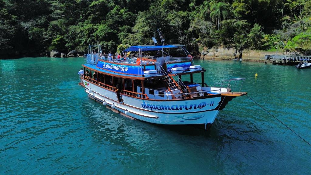 a blue and white boat in the water at Alugue de Ecuna pra casamentos, privativos, eventos e grupos in Paraty
