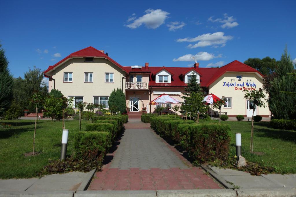 ein großes Haus mit rotem Dach in der Unterkunft Zajazd nad Wisłą in Dobrzyków