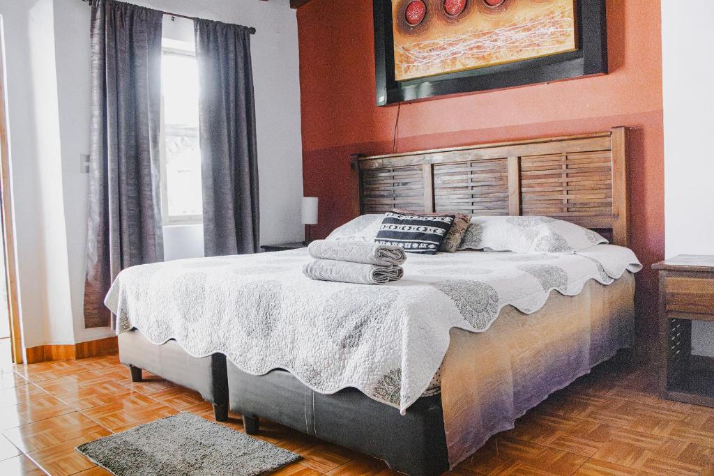 una camera da letto con un letto grande con pareti arancioni di La Ventana del Tepozteco a Tepoztlán