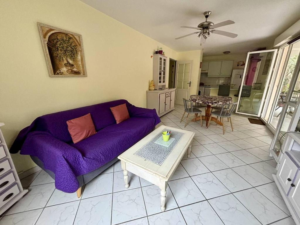 un salon avec un canapé violet et une table dans l'établissement Appartement climatisé avec garage à 200m des commerces - FR-1-816-19, à Bormes-les-Mimosas