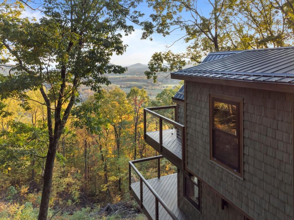 a house with a deck and a view at CloudPointe Retreat Treehouse in Stanardsville