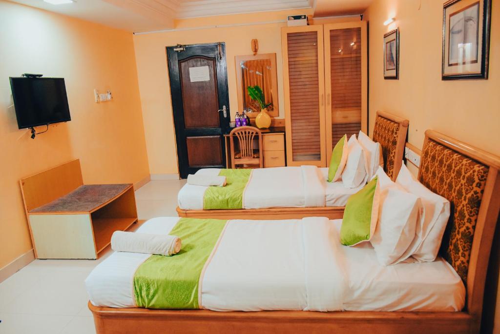 Postel nebo postele na pokoji v ubytování Naksha Tree Hotels - Mogappair