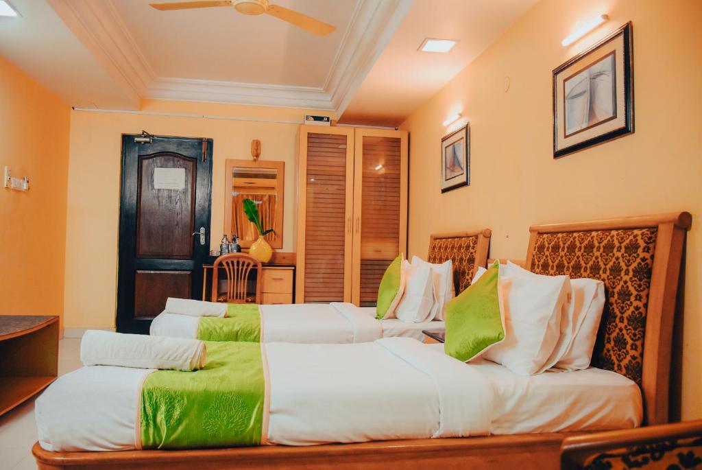 Postel nebo postele na pokoji v ubytování Naksha Tree Hotels - Mogappair