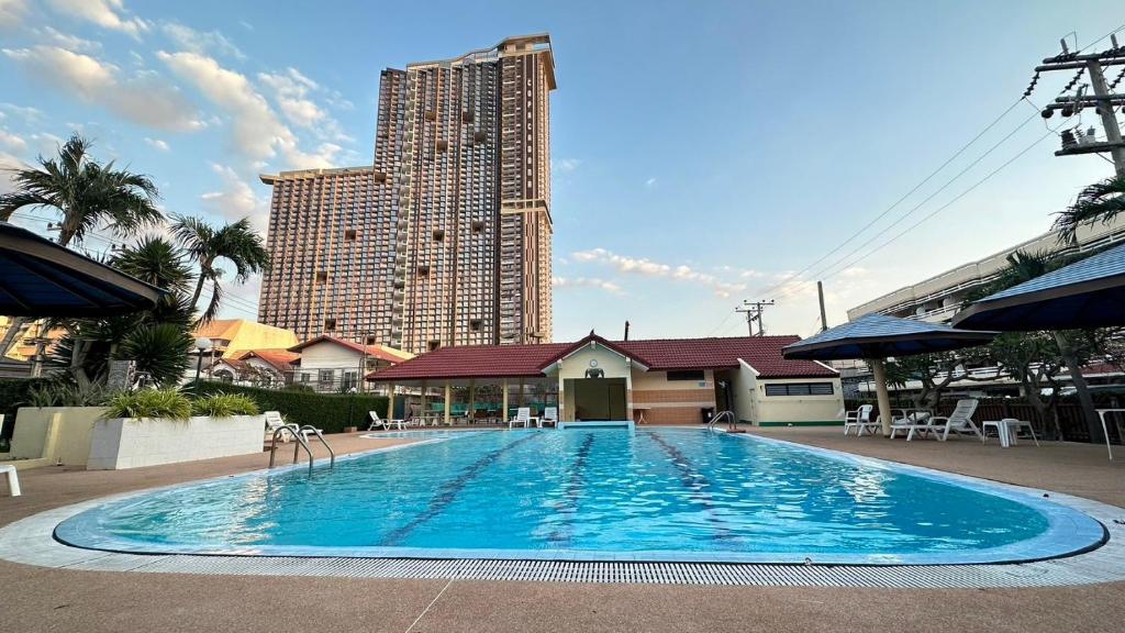 乔木提恩海滩1-Step Beach & 711! Huge Condo next to Copacabana的一座高楼前的大型游泳池