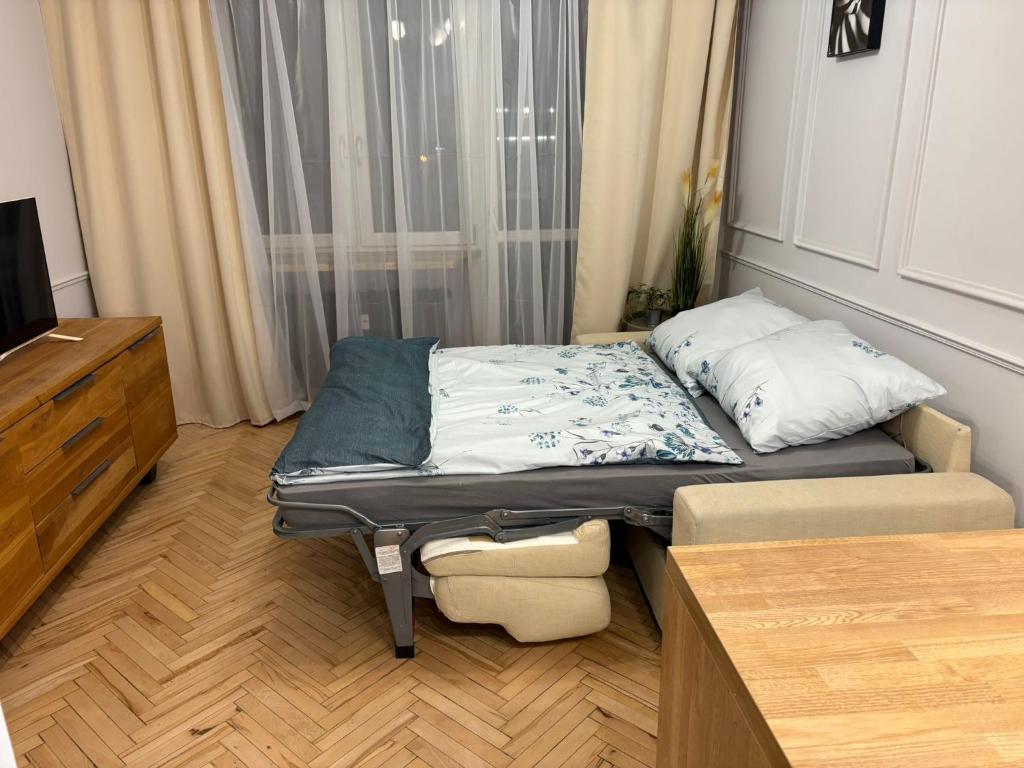 Apartament centrum في بياويستوك: غرفة صغيرة فيها سرير وتلفزيون