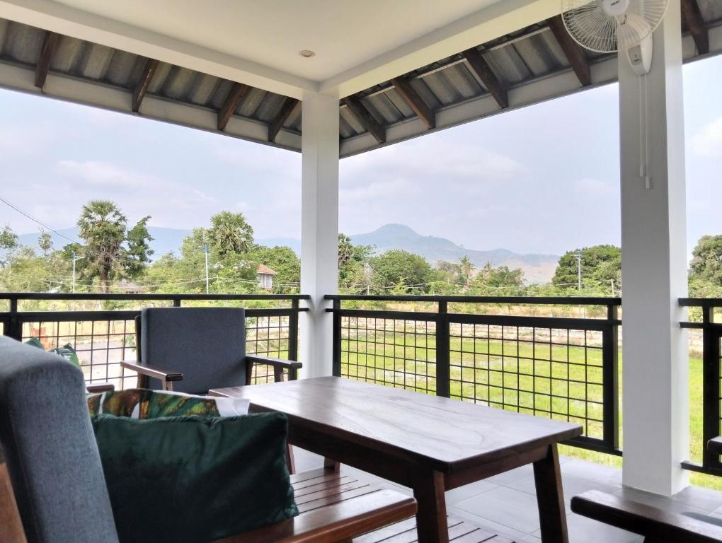 a screened in porch with a table and a view at Baksaei Retreat Ricefield Villas in Kampot