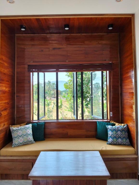 a bench in a room with a large window at Baksaei Retreat Ricefield Villas in Kampot