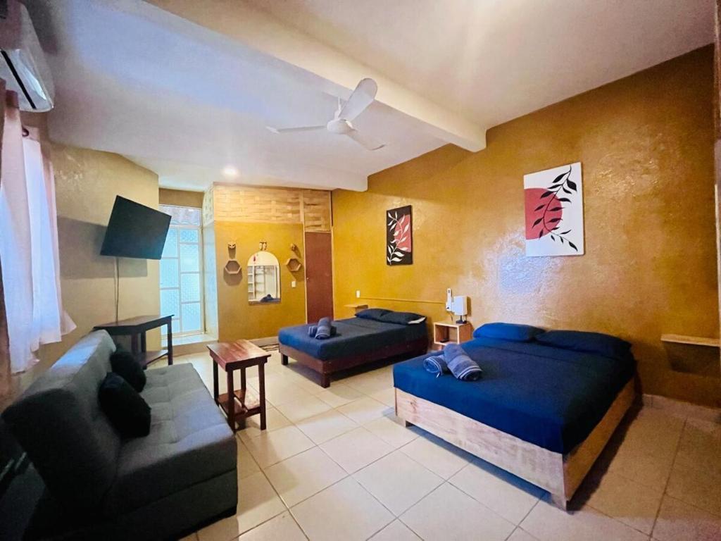 a living room with two beds and a couch at Palmar la Punta 11 AC Starlink 2min walk to beach in Brisas de Zicatela