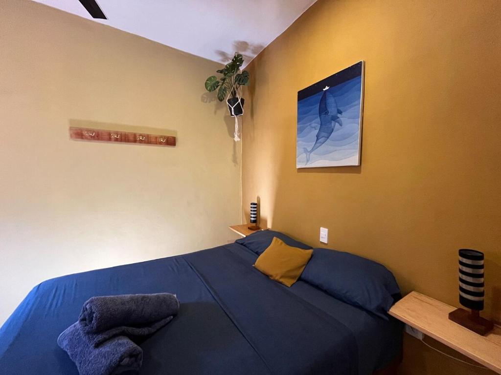 Brisas de ZicatelaにあるCasa Shula 2 AC Starlink 2min walk to beachのベッドルーム1室(青いシーツと黄色い壁のベッド1台付)
