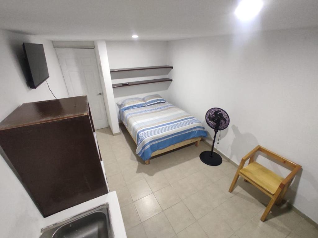 una piccola camera da letto con un letto e una scrivania di Hotelito Ejido San Ale a Momoxpan