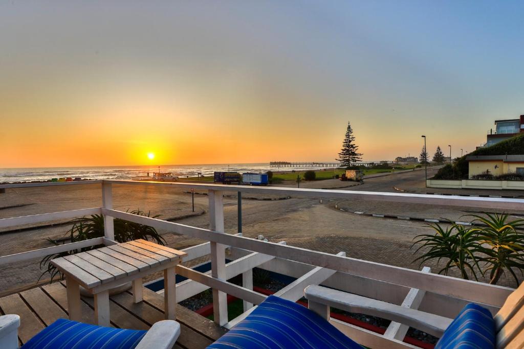 a view of the beach at sunset from a deck at Swakopmund Sands in Swakopmund