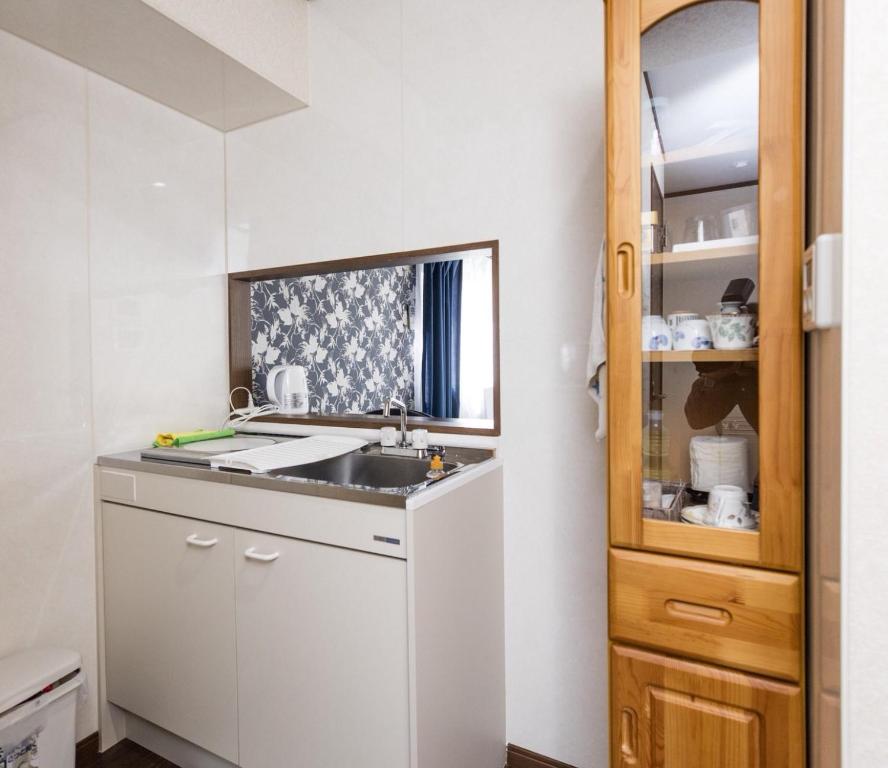 a small kitchen with a sink and a mirror at Dain Hostel1 in Tokyo