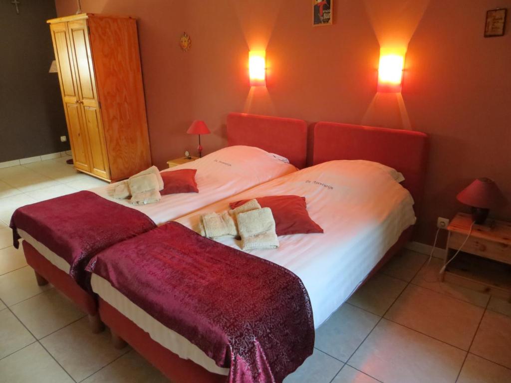 een slaapkamer met 2 bedden en rode muren bij De Aventurijn in Riemst